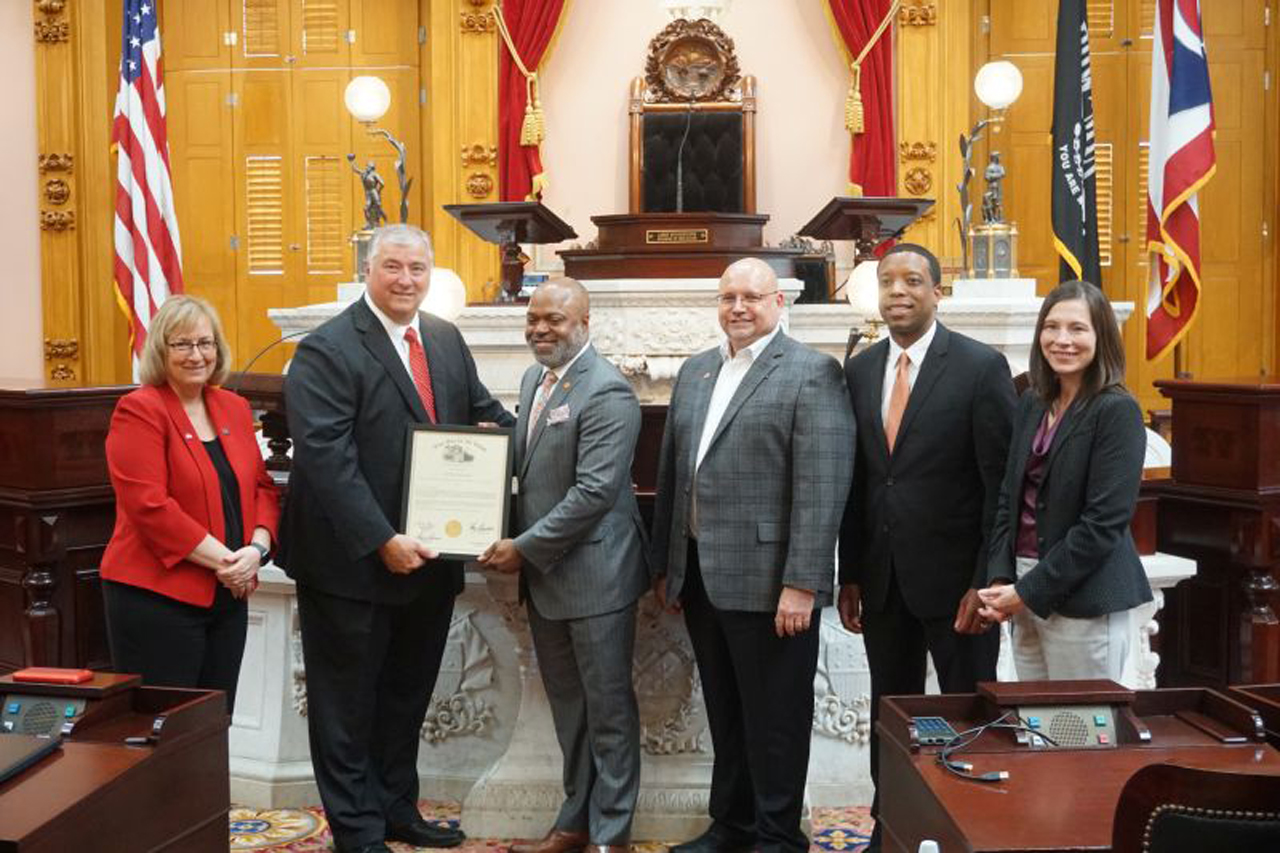 Rep. Boggs presents a commendation to COSI executives on the House floor.
