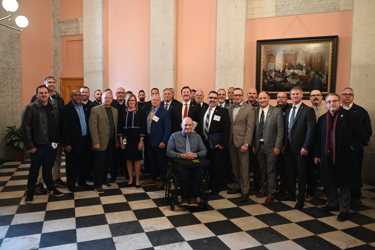 Abrams smiles with first responders and supporters of legislation to modernize the Ohio Police & Fire Pension Fund.