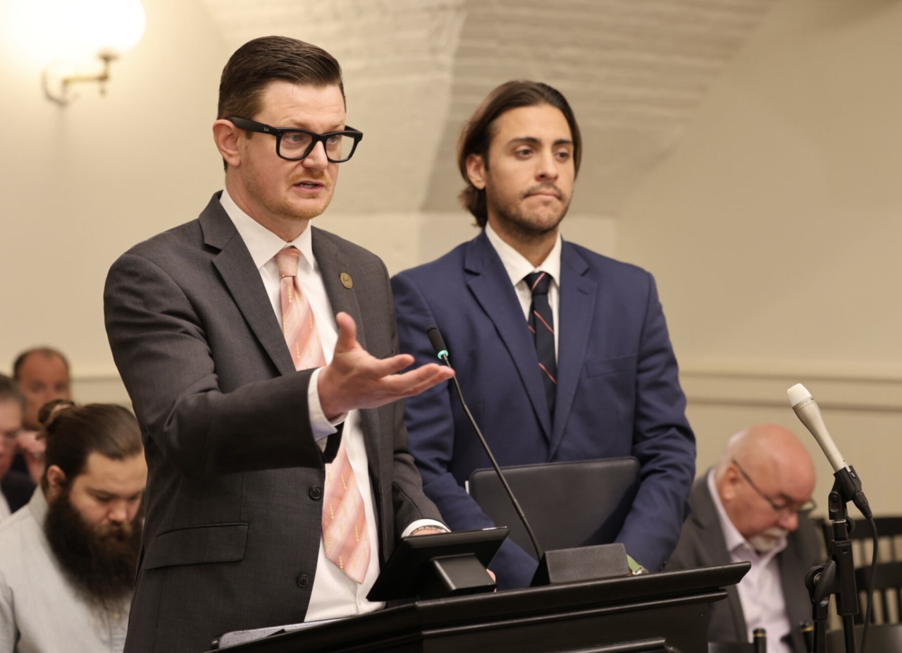 Photo of Reps. Rader and Pizzulli testifying at a podium in committee